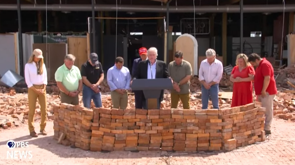 Former President Trump (red hat) prays with community members in Valdosta, Georgia on September 30, 2024 after Hurricane Helene devastated the area. Courtesy of PBS News and apnews.com.